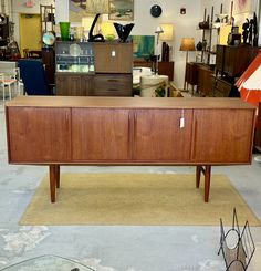 a large wooden cabinet sitting on top of a rug in a room filled with furniture