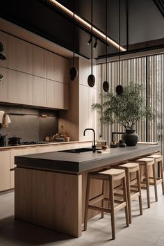 an island in the middle of a kitchen with stools next to it and a potted plant