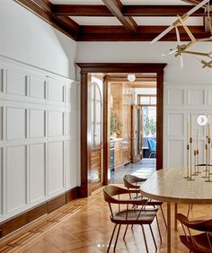 a large dining room with wooden floors and white walls, along with chandelier