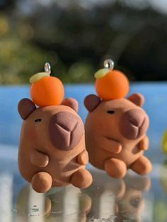 two small toy animals sitting on top of a glass table next to an orange peel