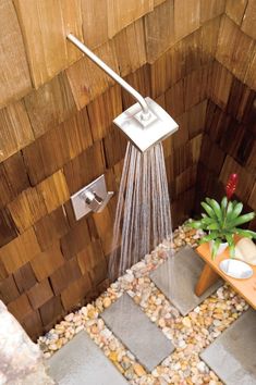 a shower head with water flowing from it's spout in a tiled bathroom