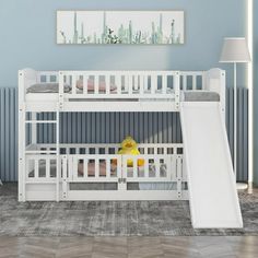 a white bunk bed with a slide in front of it and a painting on the wall