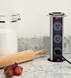 a blender sitting on top of a counter next to some strawberries and a rolling pin