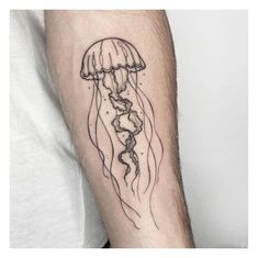 a man's arm with a jellyfish tattoo on it