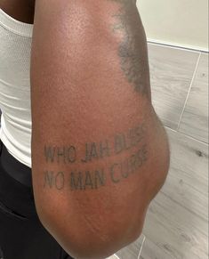 a man with a tattoo on his arm that says who jah bliss no man curse