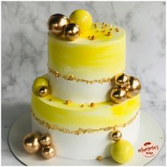 a yellow and white cake with gold decorations