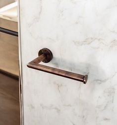 a bathroom door handle on a white marble wall