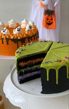 there is a cake with green icing on the plate and two other cakes in the background