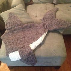 a crocheted shark blanket laying on top of a couch