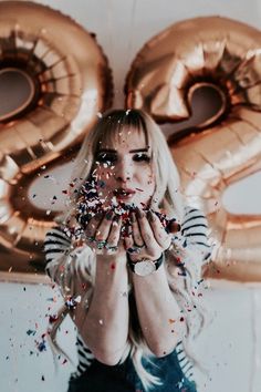 a woman holding her hands to her face with confetti in front of her