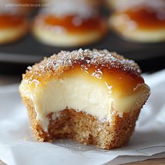 a close up of a dessert with icing and sugar on the top in front of other pastries