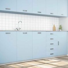 an empty kitchen with blue cabinets and white tile backsplashes on the wall