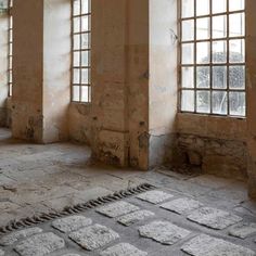 an empty room with several windows and stone flooring on the ground in front of them