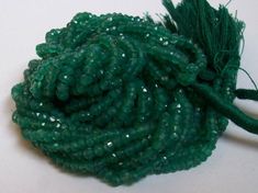 green beads with tassels are on a white surface