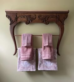 two pink towels are hanging on a towel rack