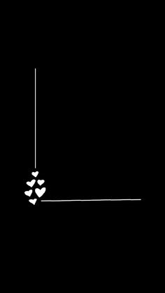 a black and white photo with two hearts hanging from a line in the middle, against a dark background