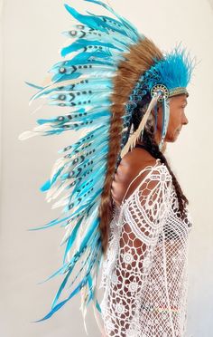 Ready to ship now, stunning real feather Indian head dress. Added small details of peacock blue ostrich feathers, crystal stones/gems, sequins. Hand decorated. Measurements 22 inches (Medium) - adjustment available to make smaller. Bright turquoise blue swam feathers with stencil design. Long white rooster feathers. Ideal for festival fun. Great as a wall Decoration or gift idea. Statement head wear. Striking display of bright blue feathers. Sits comfortably on the head, very light in weight without any movement. Comes in various other colours and can be adapted to suit your theme. One Day Shipping. Delivery to Europe 5-8 working days Delivery to UK 5-9 working days. Delivery to USA 10-20 working days Delivery to the rest of the world 10-24 working days. White Rooster, Ostrich Feather Trim, Blue Feathers, Indian Headdress, Rooster Feathers, Stencil Design, Head Dress, Feather Headdress, Flower Choker