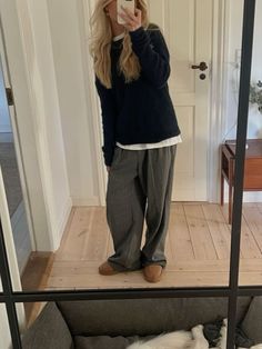 a woman taking a selfie while standing in front of a mirror with her dog