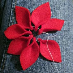 a red flower is attached to the back of a pair of jeans