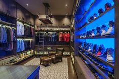 the inside of a clothing store with blue lighting and shelves full of shoes on display