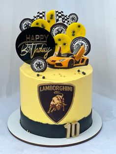 a birthday cake decorated with an lamb logo and race car on the top is yellow, black and white