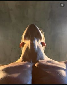 the back of a man's head and chest with light shining on him from behind