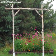 a wooden arbor with flowers in the background