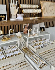 many different types of gold jewelry on display in a store with pictures and other items