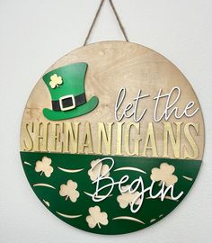 a wooden sign that says let the shennanganns begin with shamrocks on it