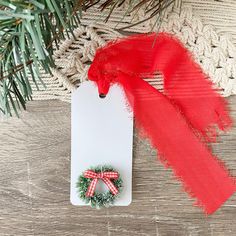 a christmas ornament with a red ribbon and a green wreath on top of it