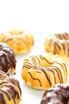 vanilla bundt cakes with chocolate glaze on a white surface and text overlay reads vanilla bundt cakes with chocolate glaze