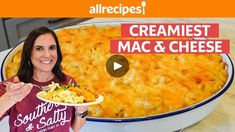 a woman holding a plate of macaroni and cheese in front of a large casserole dish