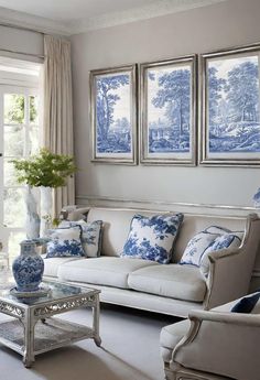 a living room with blue and white decor on the walls, couches and coffee table