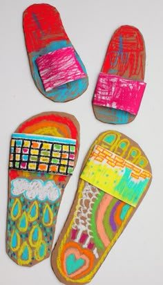 three painted shoes are shown on a white surface