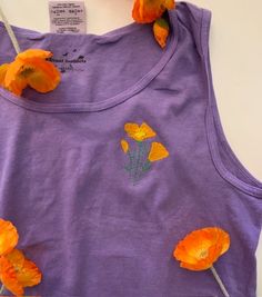 UNISEX EMBROIDERED COTTON TANK TOP California Poppy Tank is perfect addition to your drawer this summer. This California poppy embroidery is done right in house and can be customized if want a different color just let us know and we can look it up! These 100% cotton embroidered California Tank Tops are all you need for comfort with a touch of artistic pop. I hand drew each California Poppy and these are embroidered right in the back of the shop. I have been on the search for the perfect cotton tanks for this design and found them. These shirts are incredible fit and the sustainably USA grown cotton feel makes these your new favorite shirt. Embroidered at the shop! 100% Cotton Sustainably Grown USA Cotton Original Design By Jamai Lowell Unisex Sizing (size accordingly) Material: 6.1 oz/ydý, Embroidered Lavender Cotton Top, Embroidered Cotton Lavender Top, Poppy Embroidery, Graphic Tank Tops, California Poppy, Cotton Tank Top, Cotton Baby, Twill Tape, The Search