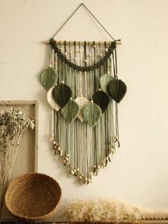 a green and white wall hanging next to a basket