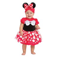 a baby girl wearing a minnie mouse costume and smiling at the camera with her hands in her pockets