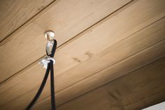 the light fixture is hanging from the ceiling in front of wood paneled walls and flooring