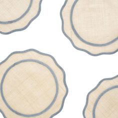 four placemats with blue and white trim on top of each other in the shape of circles