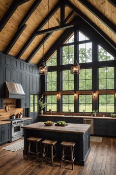 a large kitchen with wooden floors and black walls, along with an island in the middle