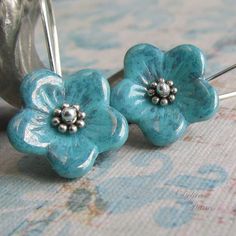 "Tiny Czech glass flowers in your choice of turquoise or antique pink swing from sterling silver French earwires. Accents of sterling silver decorate the center of these easy to wear, fun little earrings. Very cute for spring and summer! Flowers: 5/8\"(16mm)" Turquoise Nickel Free Flower Earrings, Nickel Free Turquoise Flower Earrings, Turquoise Flower-shaped Earrings With Flower Charm, Turquoise Earrings With Flower Charm, Turquoise Nickel-free Flower Earrings For Jewelry Making, Turquoise Flower Charm Earrings For Gift, Nickel-free Blue Sterling Silver Flower Earrings, Turquoise Flower Earrings As A Gift, Blue Sterling Silver Flower Earrings Nickel Free