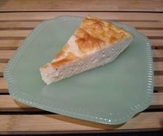 a piece of pie sitting on top of a green plate next to a wooden table