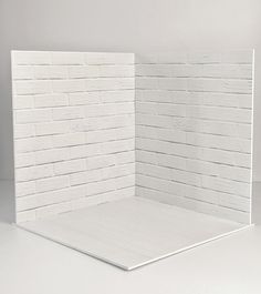 an empty room with white bricks on the wall and floor, in front of a gray background