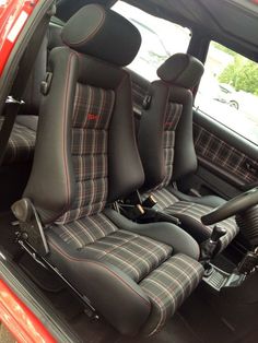 the interior of a red car with black and white plaid upholstered seats on it