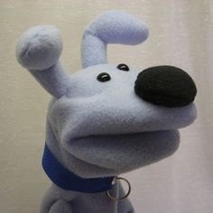 a blue stuffed animal with a black nose and ear ring on it's neck