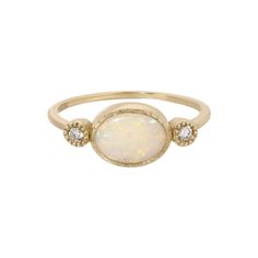 a white opal and diamond ring with three stones on the front, set in yellow gold