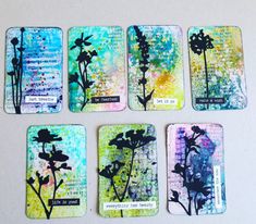 four coasters with flowers painted on them and some words written in the bottom right corner