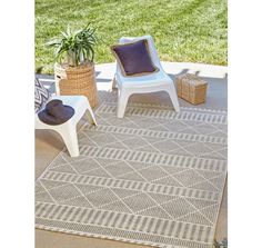 a patio area with two chairs and a rug