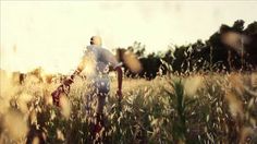 a man walking through a field with tall grass