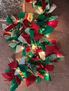 a bunch of red, green and white christmas bows are on the floor next to some lights